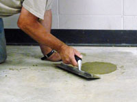 Repairing the cored holes in the concrete slab floor with fresh concrete and cleaning up the Vanier home.