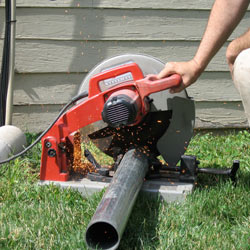 Cutting the support beam for a crawl space jack post outside a Vanier home.
