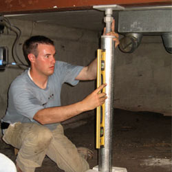 A contractor in Perth installing a crawl space jack post.