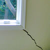 A long, diagonal crack that begins at a window corner of a Williamsburg home