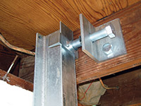Securing the i-beam system to the top of the floor joist in a foundation wall repair in Vanier.