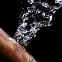 A bursting copper pipe in Kanata, with water gushing out.