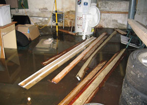 A severely flooding basement in Vanier, with lumber and personal items floating in a foot of water